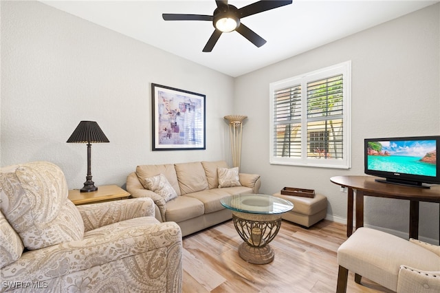 living room with baseboards, a ceiling fan, and wood finished floors