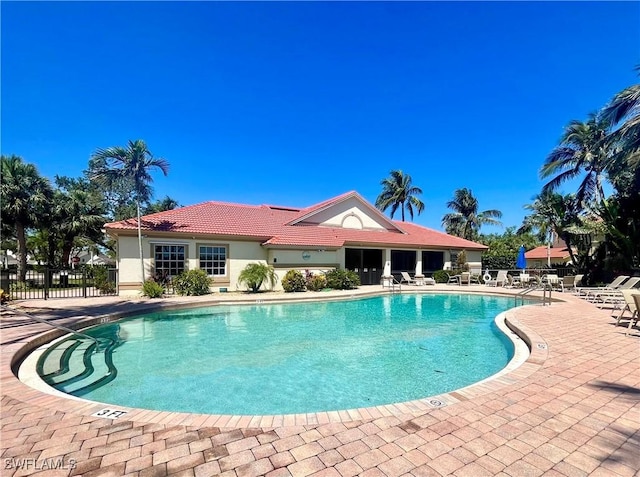 pool featuring fence and a patio area