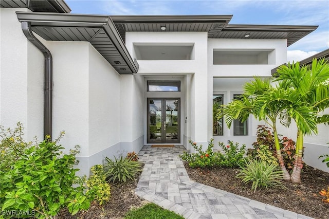 doorway to property featuring stucco siding and french doors