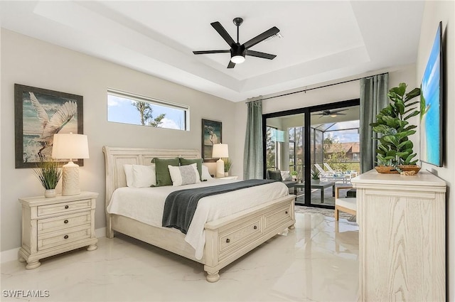 bedroom with a raised ceiling, multiple windows, access to exterior, and marble finish floor