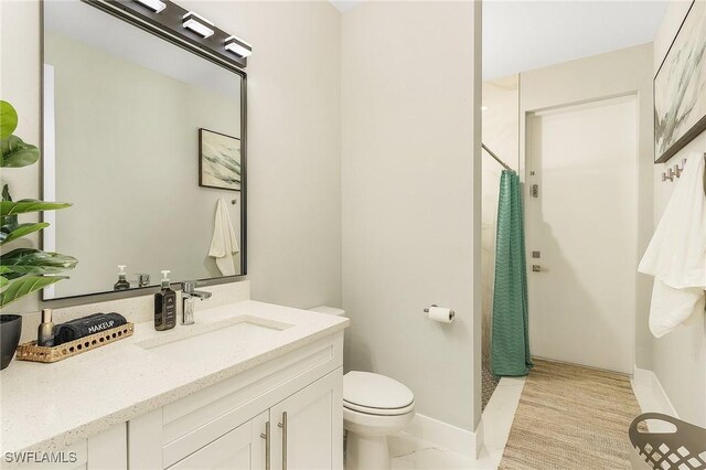 full bathroom with vanity, baseboards, toilet, and curtained shower