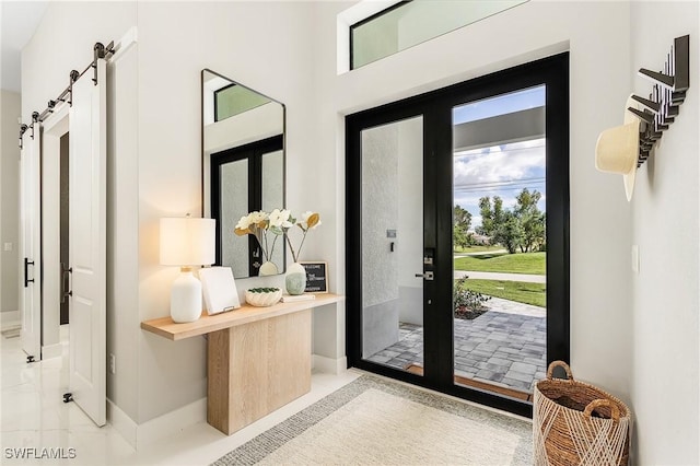 foyer entrance featuring baseboards and a barn door