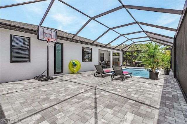 view of patio with glass enclosure and an outdoor pool