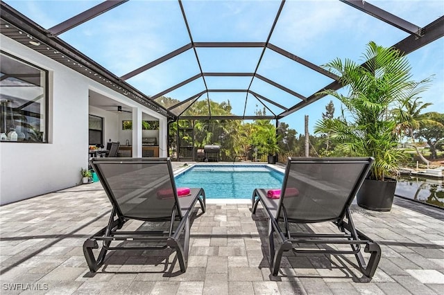 outdoor pool with ceiling fan, a lanai, and a patio area