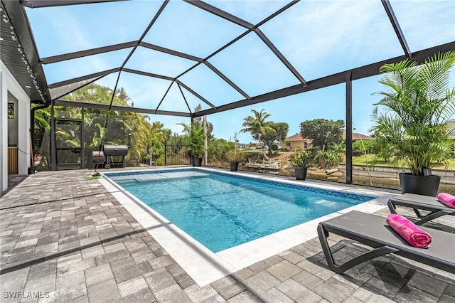 outdoor pool featuring a patio area, a lanai, and a grill