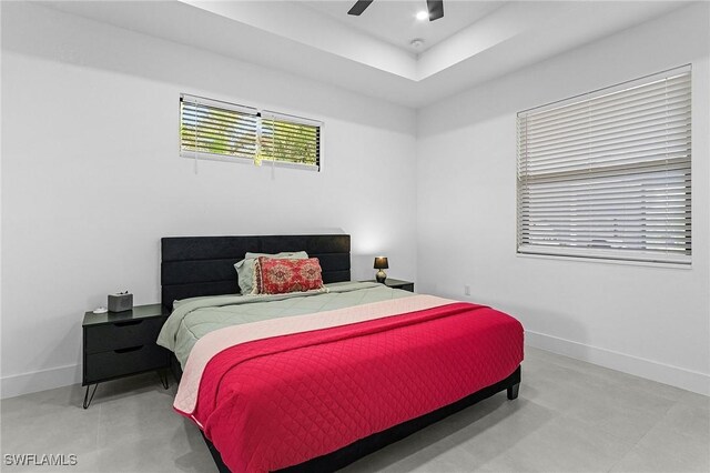 bedroom featuring baseboards, a ceiling fan, and a raised ceiling