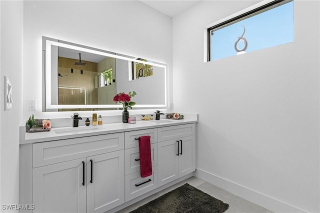 bathroom with double vanity, a sink, a shower with shower door, and a wealth of natural light