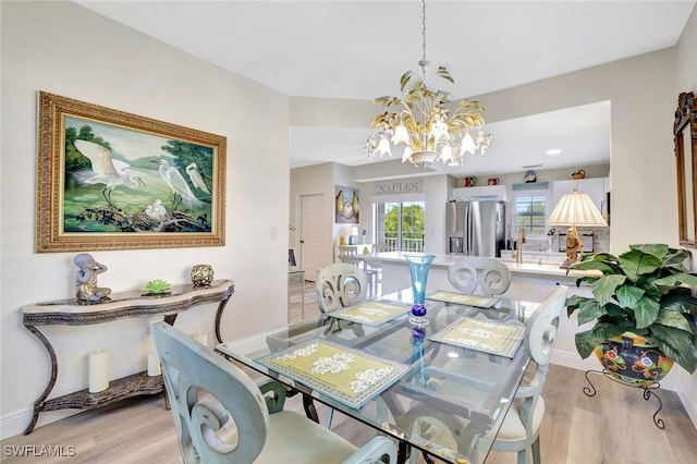4500 Botanical Place Cir Unit 301, Naples, FL 34112 - dining room with an inviting chandelier and light wood-style flooring
