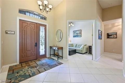3919 Aurora Ct, Naples, FL 34116 - tiled foyer with a chandelier and a towering ceiling