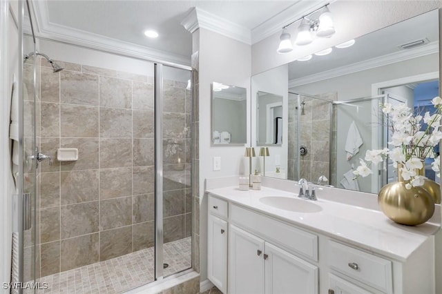 full bathroom with visible vents, crown molding, vanity, and a shower stall
