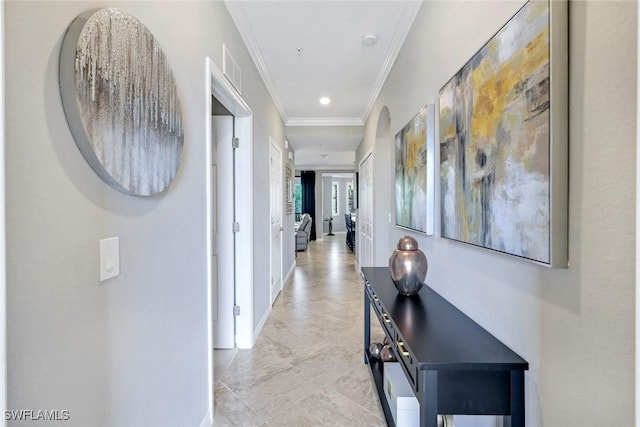 hallway with crown molding, baseboards, recessed lighting, and arched walkways