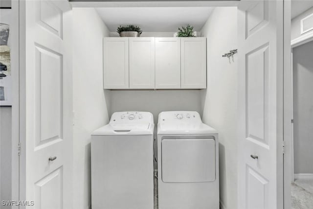 clothes washing area with independent washer and dryer and cabinet space