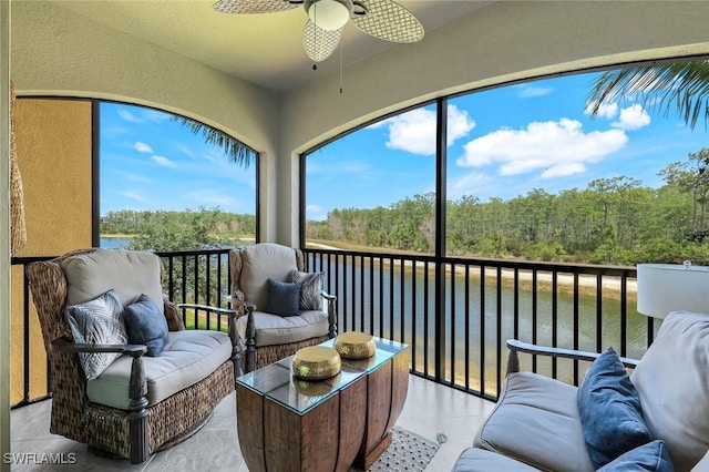 sunroom / solarium featuring a water view, outdoor lounge area, and a ceiling fan