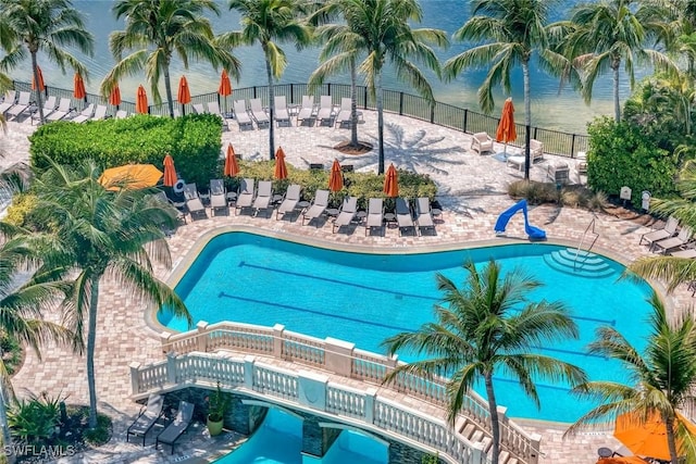 community pool with a patio area and fence