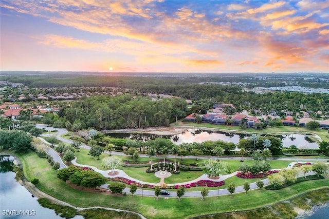 aerial view at dusk featuring a water view and a residential view