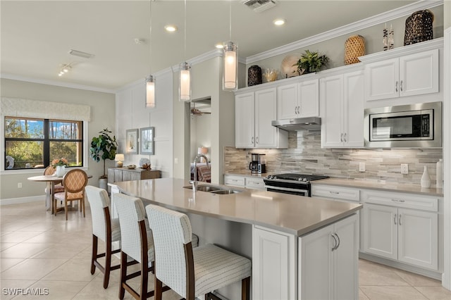 kitchen with backsplash, crown molding, appliances with stainless steel finishes, light tile patterned floors, and light countertops
