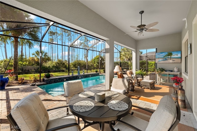 sunroom / solarium with ceiling fan and a swimming pool
