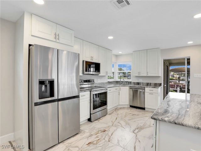 kitchen featuring stainless steel appliances, healthy amount of natural light, white cabinetry, and recessed lighting