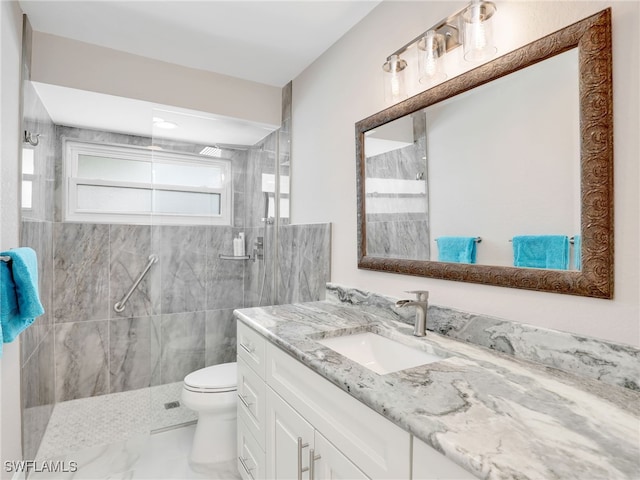 bathroom featuring marble finish flooring, a tile shower, toilet, and vanity