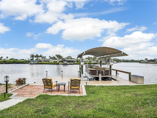dock with boat lift, a water view, and a lawn