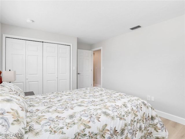 bedroom featuring a closet, baseboards, and wood finished floors