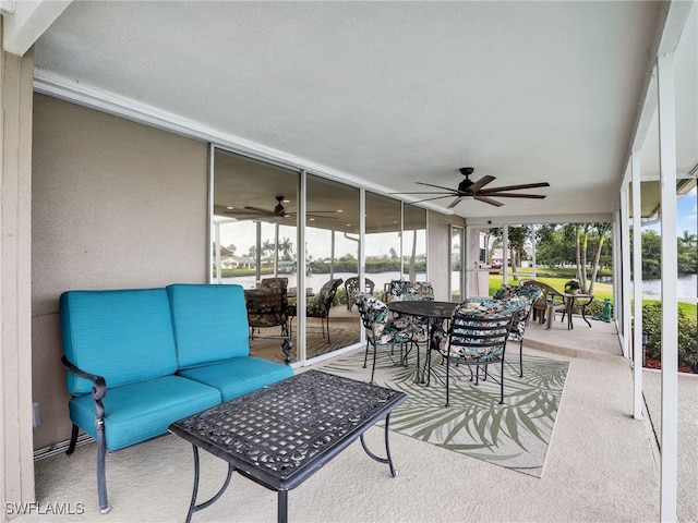 sunroom featuring a ceiling fan, outdoor dining area, and an outdoor living space
