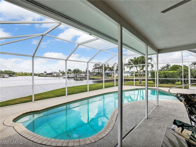 swimming pool featuring a water view, a patio, and glass enclosure