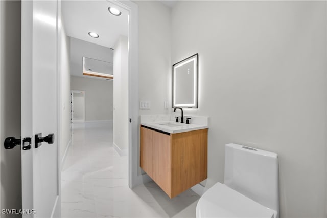 bathroom with vanity, baseboards, toilet, and marble finish floor