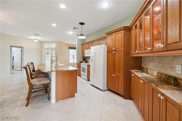 20849 Santorini Way N, Fort Myers, FL 33917 - kitchen with white appliances, recessed lighting, brown cabinetry, and tasteful backsplash