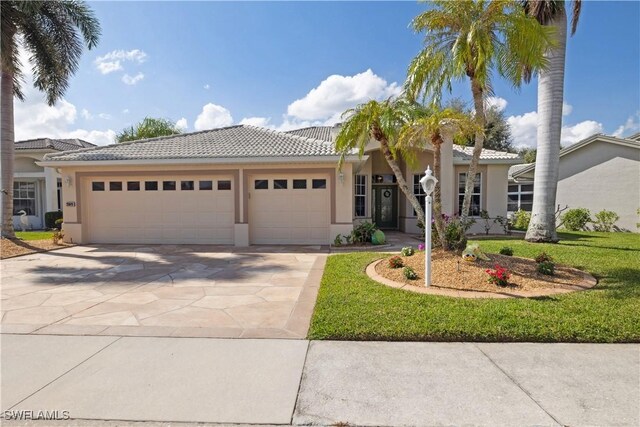 20849 Santorini Way N, Fort Myers, FL 33917 - view of front of home featuring concrete driveway, an attached garage, a tile roof, and stucco siding