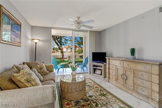living area featuring ceiling fan and marble finish floor