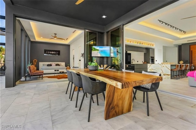 dining area featuring a raised ceiling and ceiling fan