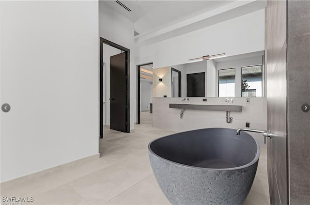 full bath with visible vents and a soaking tub