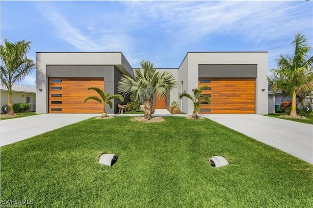contemporary house featuring stucco siding, concrete driveway, and a front lawn
