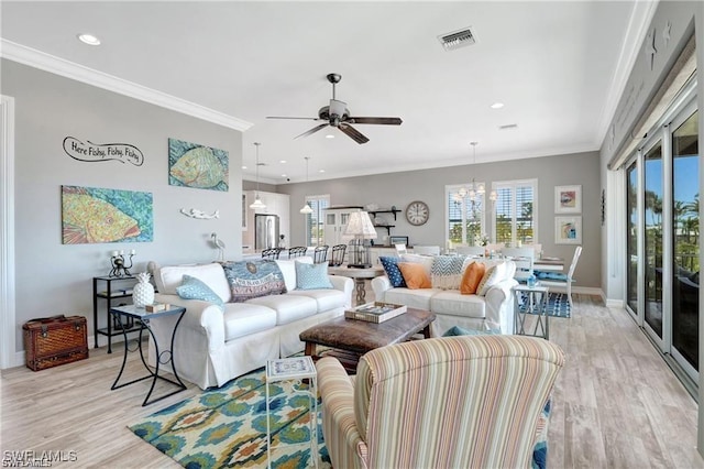 living room featuring visible vents, ornamental molding, ceiling fan with notable chandelier, and light wood-style floors