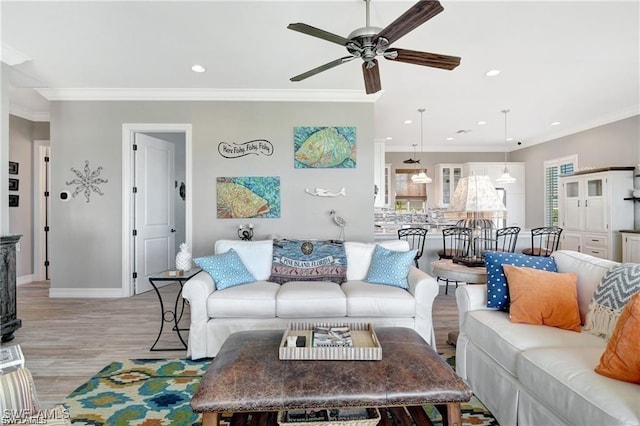 living room with light wood finished floors, a ceiling fan, baseboards, recessed lighting, and ornamental molding