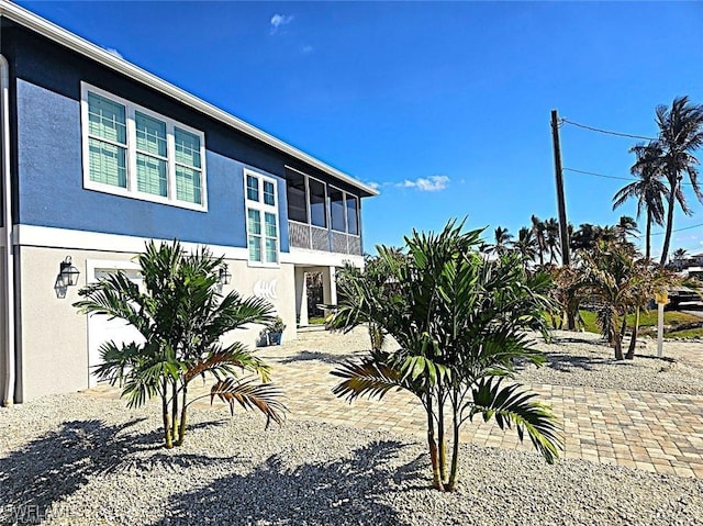 exterior space featuring stucco siding and a sunroom
