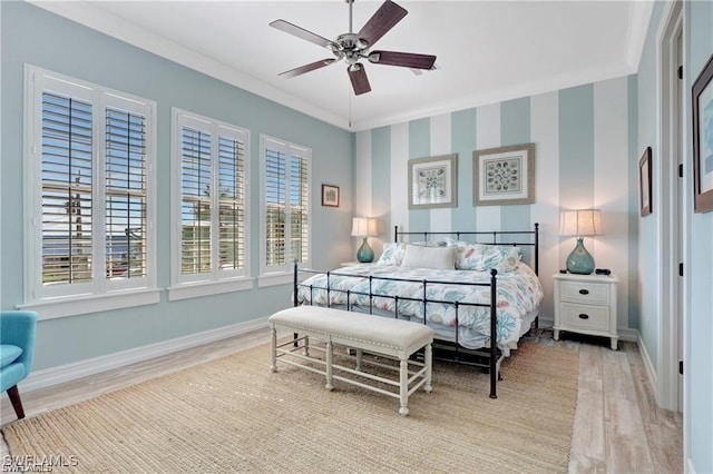 bedroom with crown molding, baseboards, ceiling fan, and light wood-style flooring