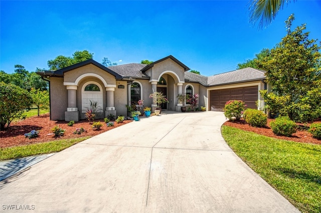 view of front of property featuring concrete driveway, a garage, and stucco siding