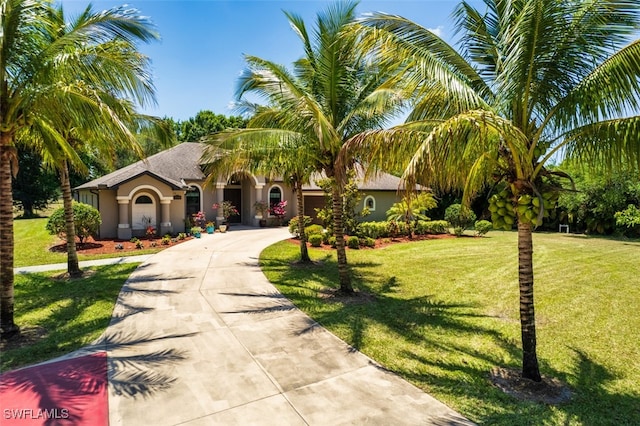 view of front facade featuring a garage, stucco siding, concrete driveway, and a front yard