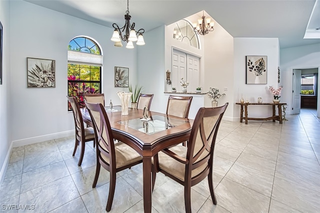 dining area featuring light tile patterned floors, baseboards, and a notable chandelier