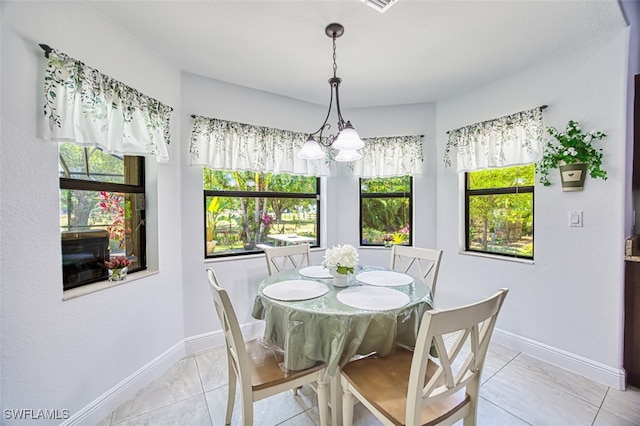dining room featuring baseboards, plenty of natural light, and a notable chandelier