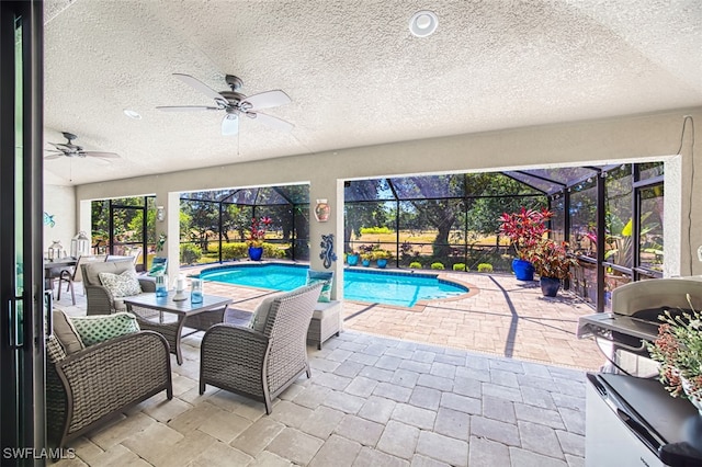 outdoor pool with a patio, a ceiling fan, glass enclosure, and area for grilling