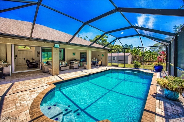 pool with a lanai, an outbuilding, a patio area, a shed, and outdoor lounge area