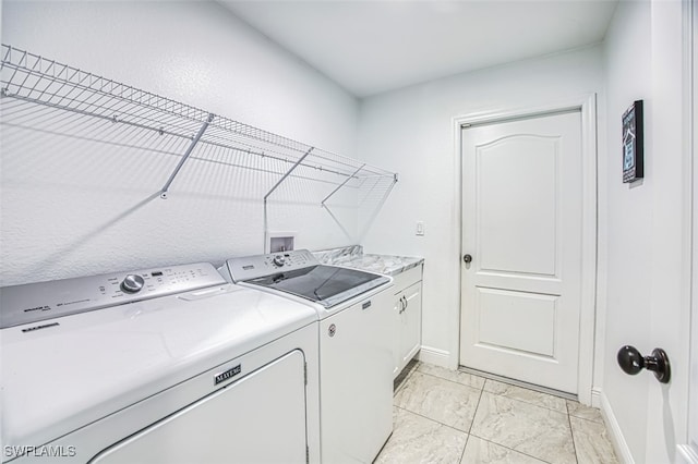 laundry room with baseboards, marble finish floor, cabinet space, and washing machine and dryer