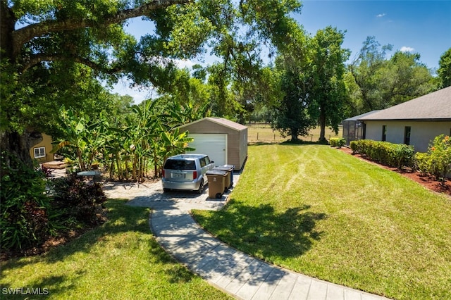 view of yard with a garage, an outdoor structure, and a shed