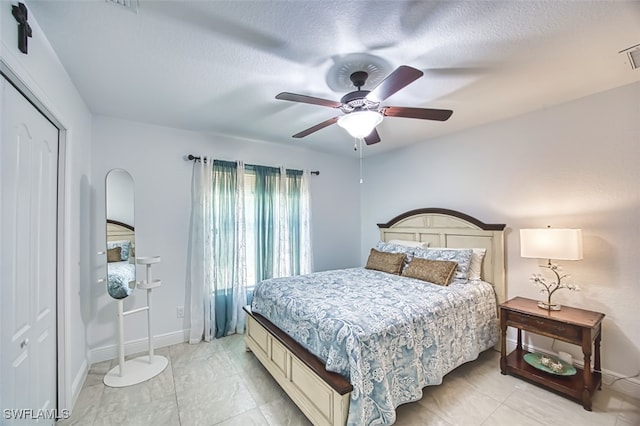 bedroom featuring arched walkways, a textured ceiling, a ceiling fan, baseboards, and visible vents