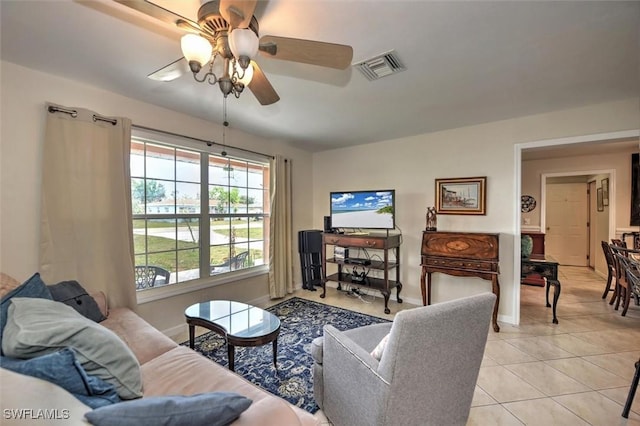 living area with light tile patterned floors, baseboards, ceiling fan, and visible vents