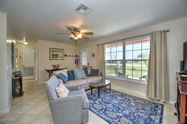 living area featuring light tile patterned floors, baseboards, ceiling fan, and visible vents