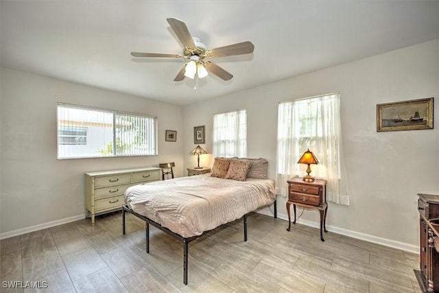 bedroom featuring baseboards, light wood-style floors, and ceiling fan